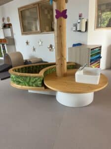 Mobilier de crèche en bois avec évier intégré et espace de jeu thématique jungle pour l'éveil des enfants.