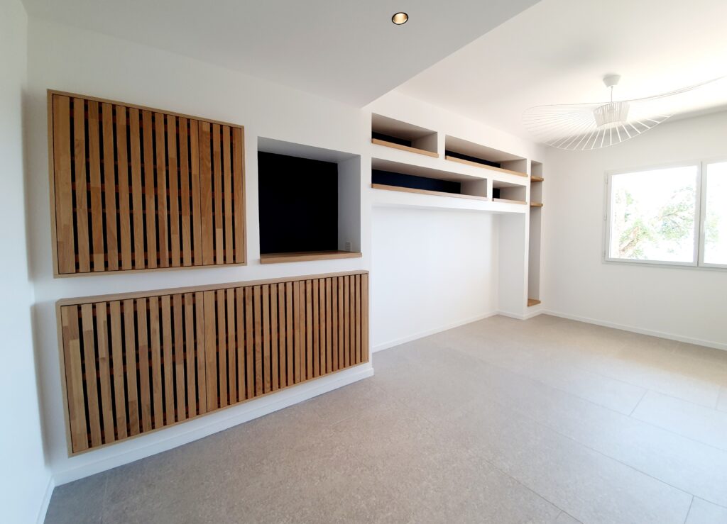 Meuble TV sur mesure et design minimaliste en bois Salon moderne avec meuble mural sur mesure, tasseaux de bois clair et étagères blanches épurées.