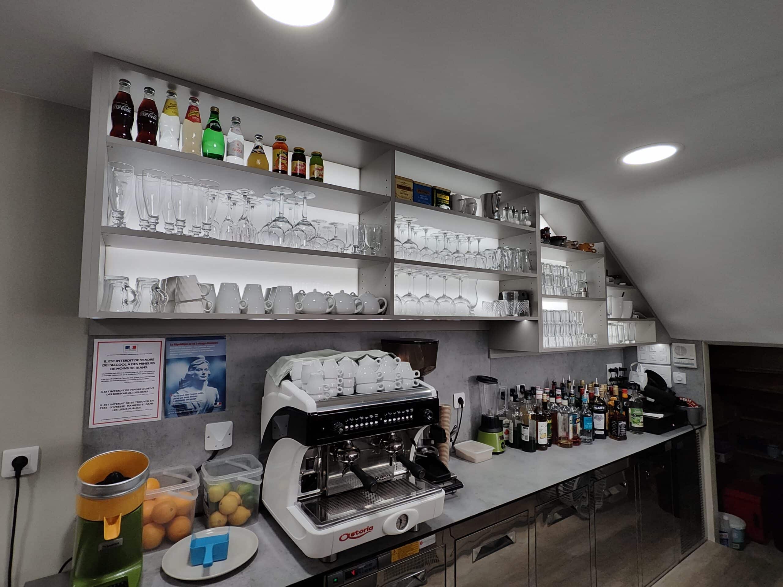 Machine Astoria, étagères de verres, bouteilles et affiche interdiction alcool aux mineurs dans un bar professionnel.